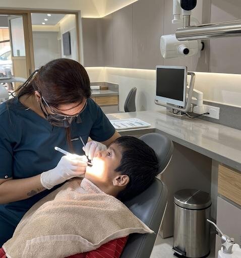 Dentist treating a young patient in the chair